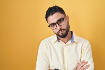 Obraz premium Hispanic young man wearing business clothes and glasses looking sleepy and tired, exhausted for fatigue and hangover, lazy eyes in the morning.