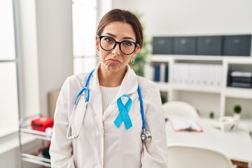 Young brunette doctor woman wearing stethoscope at the clinic depressed and worry for distress, crying angry and afraid. sad expression.