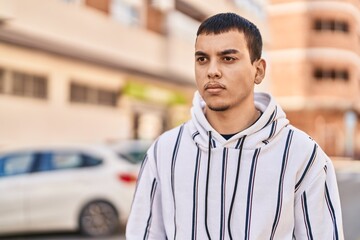 Young man with relaxed expression standing at street