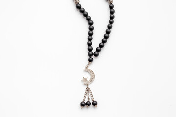 Black Muslim rosary with silver crescent moon. Islamic background