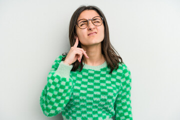 Young caucasian woman isolated on white background covering ears with fingers, stressed and desperate by a loudly ambient.