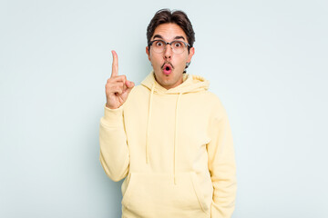 Fototapeta premium Young hispanic man isolated on blue background pointing upside with opened mouth.