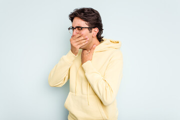 Young hispanic man isolated on blue background suffers pain in throat due a virus or infection.