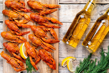 beer and beautiful boiled crayfish on a wooden table and wooden board with dill and lemon