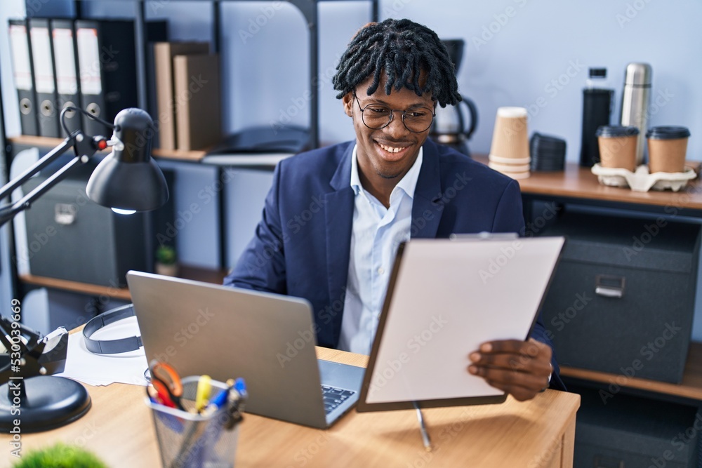 Wall mural african american man business worker using laptop reading document working at office