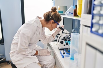 Young blonde woman wearing scientist unifomor working at laboratory