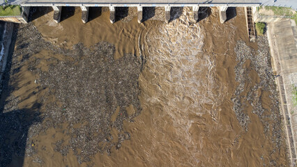 Aerial view of water released from the drainage channel of the concrete dam is a way of overflowing...