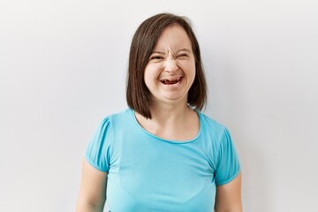 Young down syndrome woman standing over isolated background winking looking at the camera with sexy...
