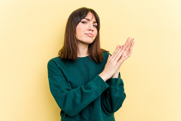 Young caucasian woman isolated on yellow background feeling energetic and comfortable, rubbing hands confident.