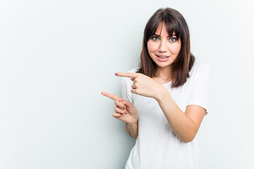 Young caucasian woman isolated on white background shocked pointing with index fingers to a copy space.