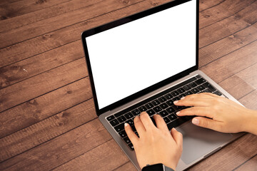 Modern laptop mock up,  woman hands typing on modern laptop mock up. Notebook on wooden table. Caucasian female hands on white blank screen or display computer. Browsing internet, using technology.