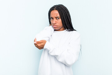 Young African American woman with braids hair isolated on blue background having a neck pain due to stress, massaging and touching it with hand.