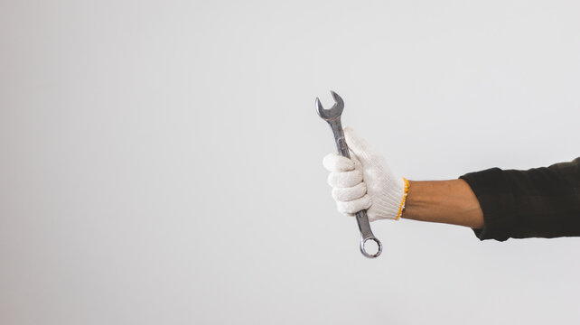 Male mechanic hands holding wrench in studio against white background
