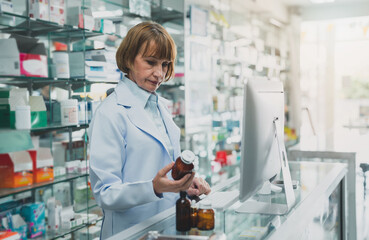 adult recommends a bottle of medicine .pharmacist woman advice At the pharmacy.Pharmacy and health care business.Professional seller medicamen.