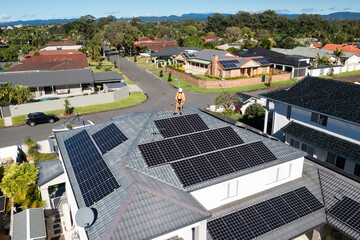 Solar panels and technician on luxury waterfront home
