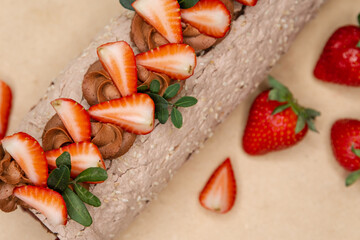 Perfect summer season dessert served on rustic wooden board. Homemade strawberry shortcake cake roll with cream cheese whipped cream. Chocolate roll with strawberries. Swiss roll cake cream.