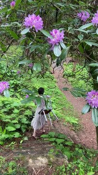 woman holding white chair walking in the garden
