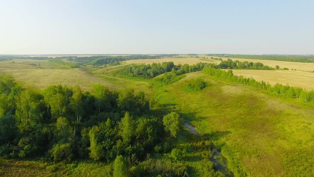 Rural landscape with small river in foggy dawn. Morning in countryside. Aerial stock footage shot at summer season time.