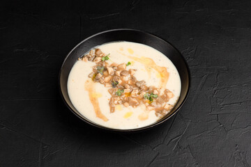 Soup, soup with chicken and cream on a black background side view