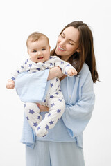 vertical portrait of smiling mother and baby, child, woman in blue clothes holding baby in her arms on white background