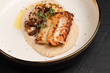 mashed fish, fried fish on a black background side view