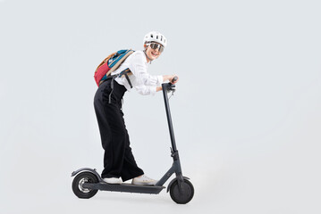 An Asian women rides an electric scooter to work.