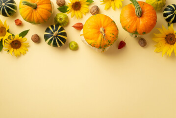 Thanksgiving day concept. Top view photo of sunflowers vegetables pumpkins pattypans walnuts and physalis on isolated beige background