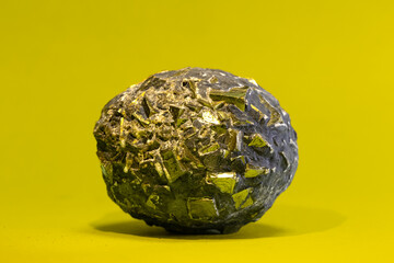 Raw pyrite is iron sulfide that crystallizes in the cubic system on isolated yellow background. Because of its golden color, it is also called "fool's gold" because it is often confused with gold. 