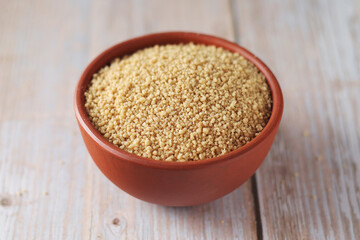 Dry couscous in a small ceramic bowl	