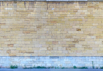 Ancien mur de pierres dorées rectangulaires sur une base de pierres grises
