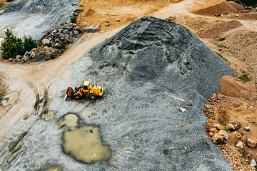 Aerial view of Truck excavator in open sand quarry rubble in Finland.