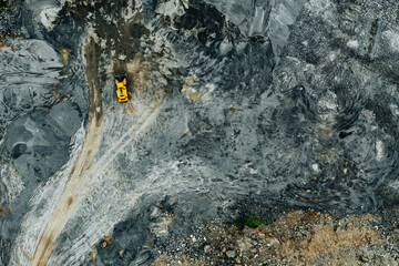 Aerial view of Truck excavator in open sand quarry rubble in Finland.