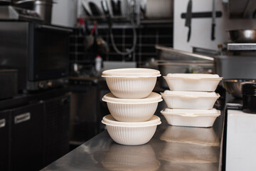 plastic containers and bowls with prepared food for charity in kitchen.
