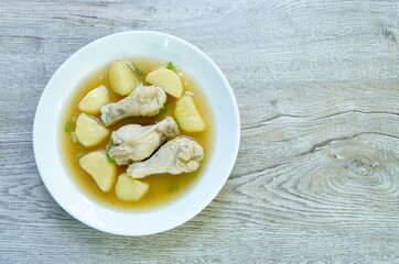 boiled chicken leg with potato in gravy sauce stew on plate