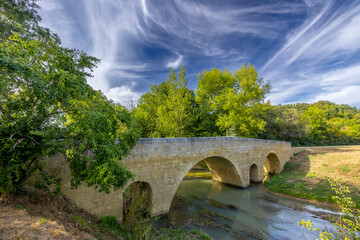 Romanesque bridge of Artigue and river Osse near Larressingle on route to Santiago de Compostela,...