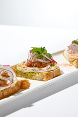 Aesthetic composition with tomato bruschetta on white background with harsh shadows. Italian bruschetta with tomatoes and cheese on fine dining in summer. Elegant menu concept.