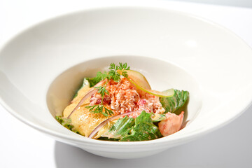 Elegant salad with crab meat, espuma sauce and lettuce on white table with harsh shadows. Green salad with crab and creamy sauce in summer menu. Aesthetic food. Seafood appetizer.