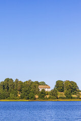 Fototapeta na wymiar Lake with a country house on a hill