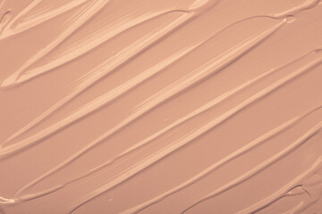 Foundation smeared as a swatch as a close-up background. Makeup cosmetics. Tone cream. Concealer texture.