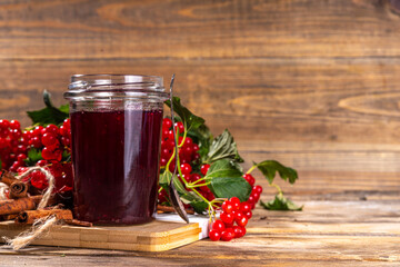 Autumn jam recipe, conservation and harvest season. Homemade red jam from organic viburnum berries, with fresh berries on twigs and cinnamon