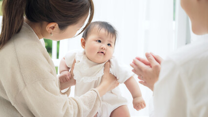 赤ちゃんと遊ぶ両親　家族イメージ