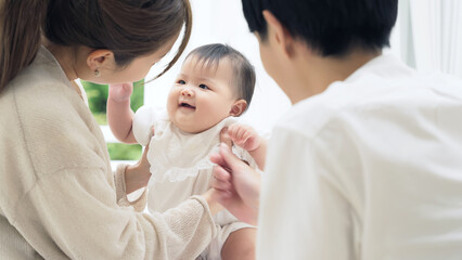 Fototapeta na wymiar 赤ちゃんと遊ぶ両親　家族イメージ