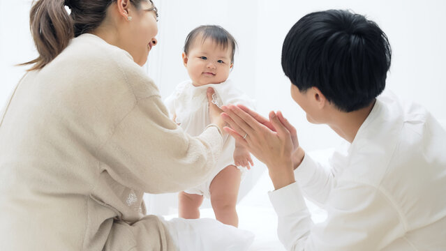 赤ちゃんと遊ぶ両親　家族イメージ