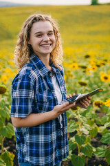 Smiling happy curly woman using modern technologies for production of agricultural products in...