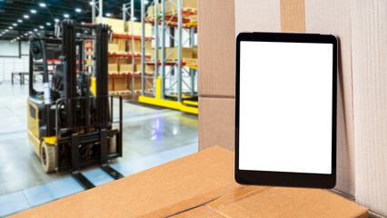 Warehouse applications. Tablet with blank screen. Tablet computer on boxes. Application for tracking warehouse balances concept. Warehouse fulfillment technologies. Blurred forklift behind tablet © Grispb