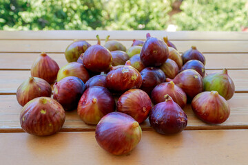 Pile of ripe purple figs on wooden garden table