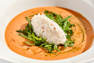 Summer Spanish soup gazpacho with crab meat and rucola isolated on white background. Delicious cold tomato soup with crab. Clean eating for diet.Healthy food in restaurant menu. Crab gazpacho
