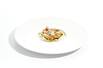 Restaurant dish - shrimp tartare with avocado, cream cheese, sweet chilli sauce on white plate. Ceviche with marinated prawn, avocado and spicy vegetables. Prawn tartare isolated on white background.