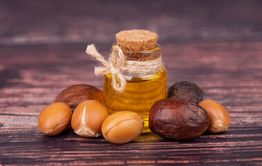 Argan oil on wooden background. Argan nuts and seeds, for cosmetic and beauty products. Natural argan fruit from Morocco.