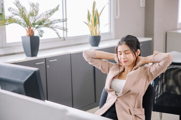 A businesswoman who works in the office looks tired and stressed by pressing her hands